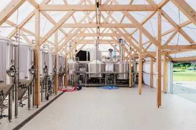 a large timber frame barn with a train inside at Hopspot in Evergem