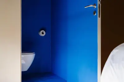 a blue room with a toilet and a blue wall at Hopspot in Evergem