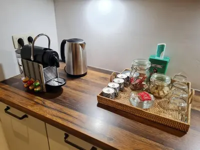 a counter top with a tray of food and a coffee maker at Studio chaleureux & moderne, région bruxelloise in Asse