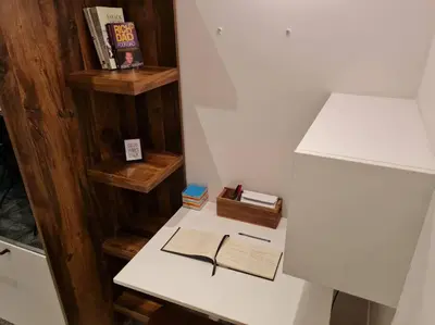 a white desk with books and a book at Studio chaleureux & moderne, région bruxelloise in Asse