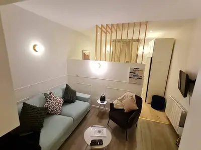 a living room with a blue couch and chairs at Studio chaleureux & moderne, région bruxelloise in Asse