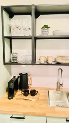 a kitchen counter with a sink and some glasses at Appart Brussels EXPO & ATOMIUM in Grimbergen