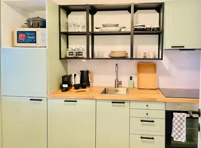 a kitchen with white cabinets and a sink at Appart Brussels EXPO & ATOMIUM in Grimbergen
