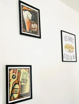 three framed pictures of food and drinks on a wall at Appart Brussels EXPO & ATOMIUM in Grimbergen