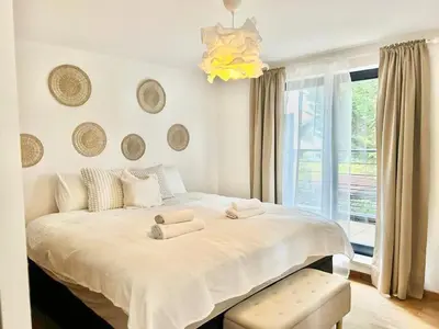 a bedroom with a large white bed with a window at Appart Brussels EXPO & ATOMIUM in Grimbergen