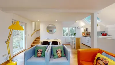 a living room with a blue couch and a kitchen at The Tile House - 2 bedroom property just south of Brussels in Sint-Genesius-Rode