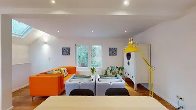 a living room with an orange couch and a table at The Tile House - 2 bedroom property just south of Brussels in Sint-Genesius-Rode