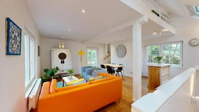 a living room with an orange couch and a table at The Tile House - 2 bedroom property just south of Brussels in Sint-Genesius-Rode