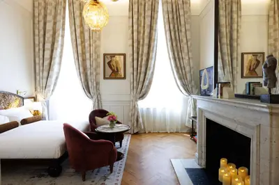 a living room with a bed and a fireplace at Hotel Fleur de Ville in Brussels
