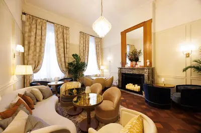 a living room with a couch and chairs and a fireplace at Hotel Fleur de Ville in Brussels