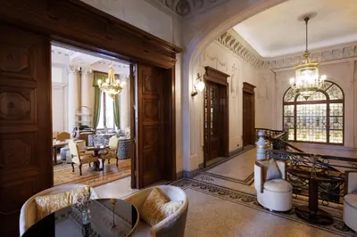 a living room with a chandelier and a dining room at Hotel Fleur de Ville in Brussels