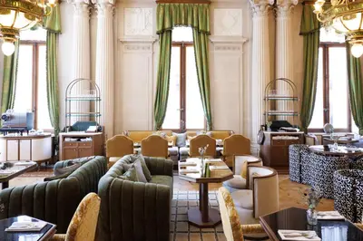 a living room with couches and tables and windows at Hotel Fleur de Ville in Brussels