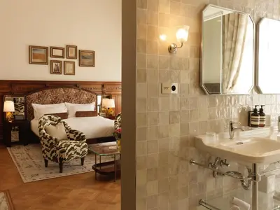 a bathroom with a sink and a bed with a mirror at Hotel Fleur de Ville in Brussels