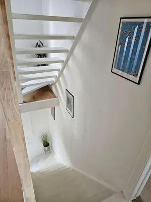 a white staircase with a plant in a room at BNB Green refuge: Vakantiehuis met zeer grote tuin in Londerzeel
