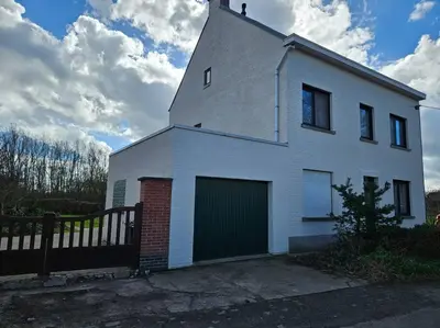 a white house with a green garage at BNB Green refuge: Vakantiehuis met zeer grote tuin in Londerzeel