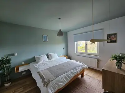 a bedroom with a large bed and a window at BNB Green refuge: Vakantiehuis met zeer grote tuin in Londerzeel