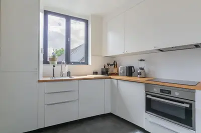a white kitchen with a sink and a window at Cosy duplex nearby city centre of Ghent for 6 in Ghent