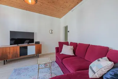 a living room with a red couch and a tv at Cosy duplex nearby city centre of Ghent for 6 in Ghent