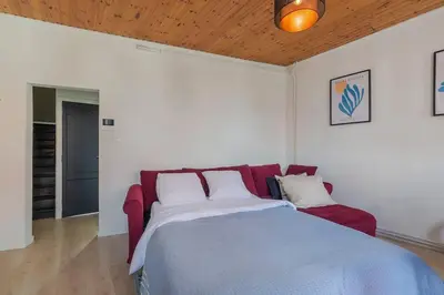 a bedroom with a large bed and a red couch at Cosy duplex nearby city centre of Ghent for 6 in Ghent