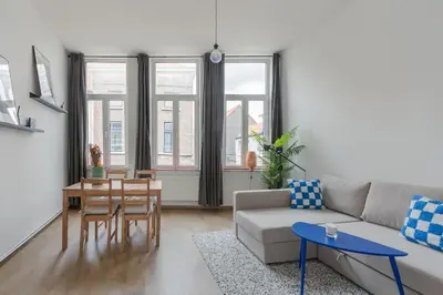 a living room with a couch and a table at Ruime studio in centrum voor 4 in Ghent