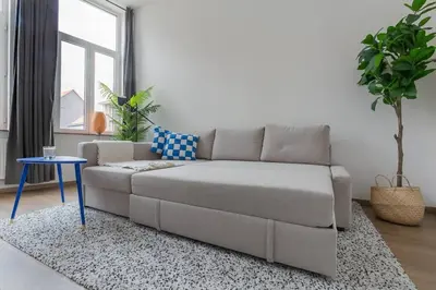 a living room with a couch and a table at Ruime studio in centrum voor 4 in Ghent
