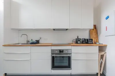 a kitchen with white cabinets and a sink and a stove at Ruime studio in centrum voor 4 in Ghent