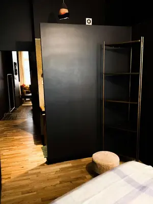 a room with a bed and a black wall at Sān home’s in Antwerp