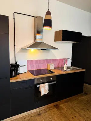 a kitchen with a sink and a stove top oven at Sān home’s in Antwerp