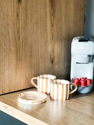 two cups sitting on a counter next to a coffee maker at Sān home’s in Antwerp