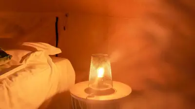 a lamp sitting on a table next to a bed at KARIBU - Olifant in Kasterlee