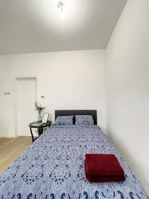 a bedroom with a bed with a red pillow on it at Elegant Flat Cinquantenaire in Brussels