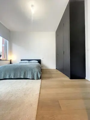 a bedroom with a bed and a black closet at Elegant Flat Cinquantenaire in Brussels