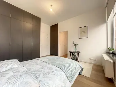 a bedroom with a large bed and a window at Elegant Flat Cinquantenaire in Brussels