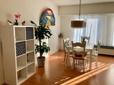 a dining room with a table and a table and chairs at Charming Sunny 100m2 Entire Apartment with 2 bedrooms in Brasschaat