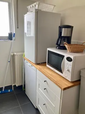 a microwave sitting on top of a counter next to a refrigerator at Charming Sunny 100m2 Entire Apartment with 2 bedrooms in Brasschaat