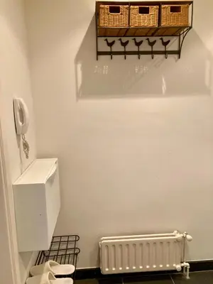 a bathroom with a toilet and a basket on the wall at Charming Sunny 100m2 Entire Apartment with 2 bedrooms in Brasschaat