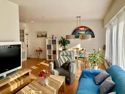 a living room with a blue couch and a tv at Charming Sunny 100m2 Entire Apartment with 2 bedrooms in Brasschaat