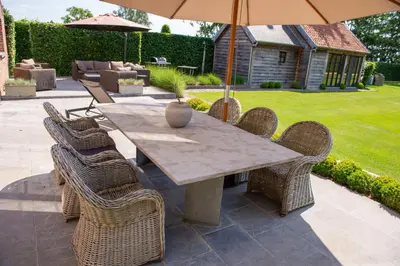 a table with chairs and an umbrella on a patio at B&B Fragaria in Hoogstraten