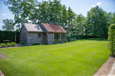 a house with a large lawn in front of it at B&B Fragaria in Hoogstraten