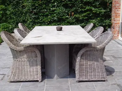 a table with wicker chairs and a vase on it at B&B Fragaria in Hoogstraten