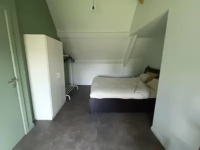 a small bedroom with a bed and a closet at Huis Belijn in Lokeren