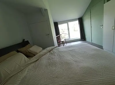 a bedroom with a large bed and a window at Huis Belijn in Lokeren