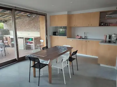 a kitchen with a wooden table and chairs at Huis Belijn in Lokeren