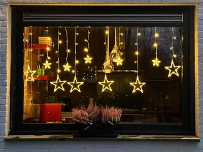 a window with christmas lights and stars on it at Kokoon in 't groen in Leuven