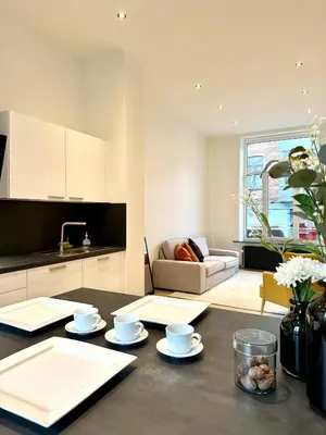 a kitchen and living room with a table with dishes on it at My Haus European Commision in Brussels