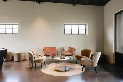 a group of chairs and a table in a room at Schuur 80 in Haasdonk