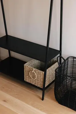 a black console table with a basket under it at Schuur 80 in Haasdonk