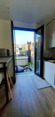an open door to a kitchen with a view at The South Suite - trendy duplex op het Zuid in Antwerp