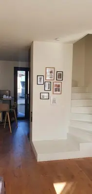 a room with stairs and pictures on a wall at The South Suite - trendy duplex op het Zuid in Antwerp