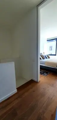 a bedroom with a bed and a large window at The South Suite - trendy duplex op het Zuid in Antwerp